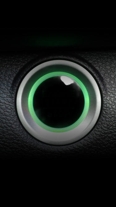 A car engine button lit up in green