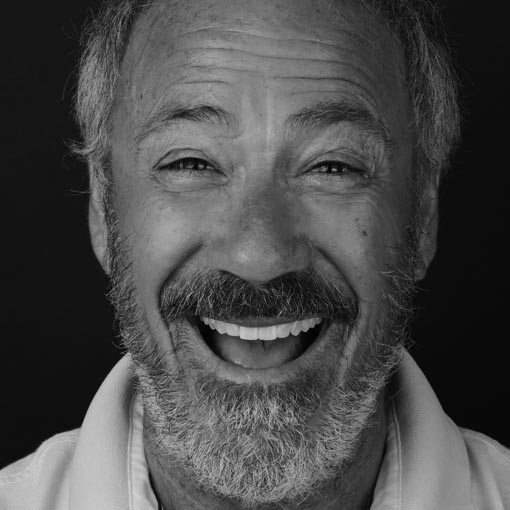 A man with a beard and moustache smiles broadly and happily to show his new teeth after dental treatment.