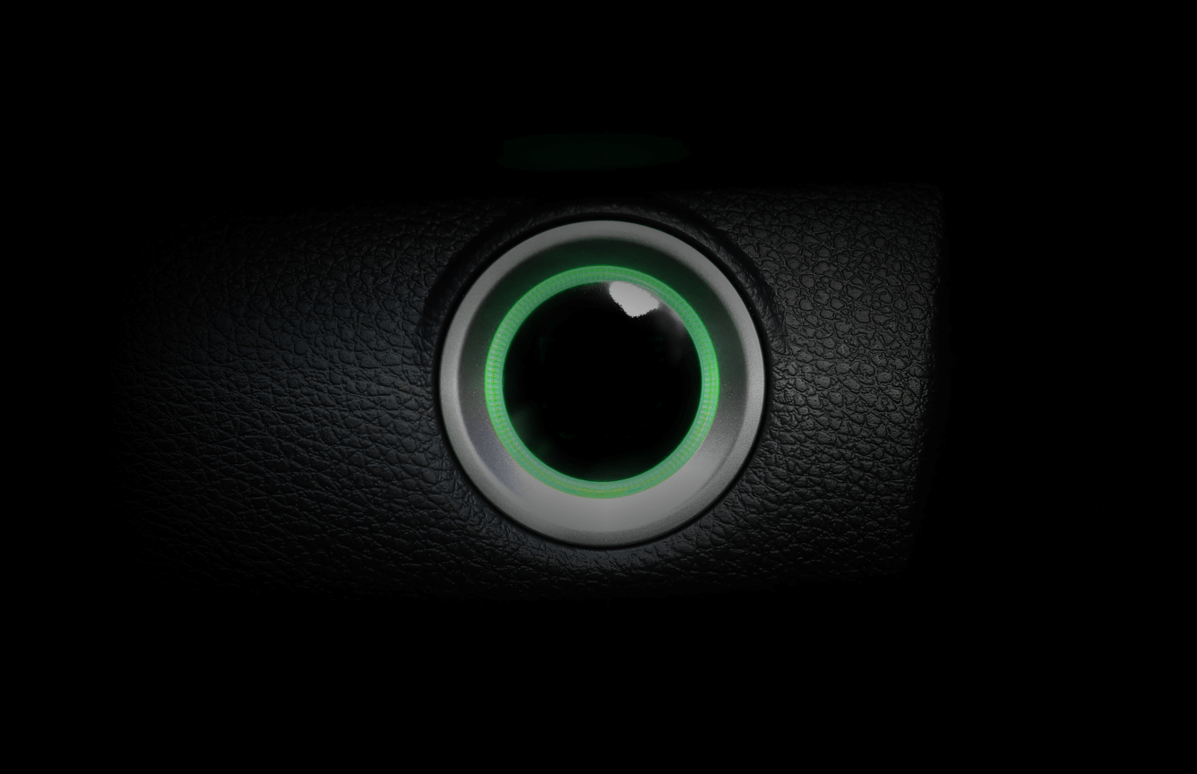 A car engine button lit up in green